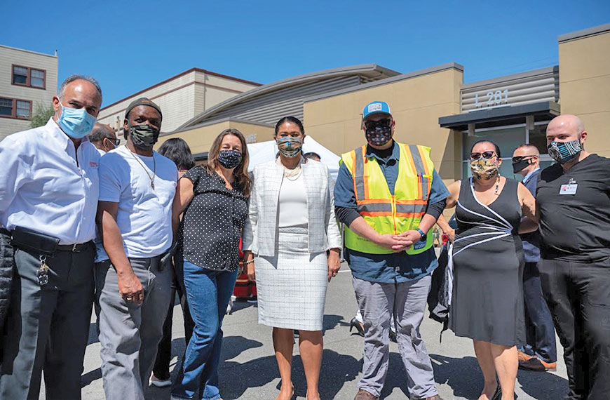 San Francisco Mayor London Breed stands with Laborers 261 members and others during the grand opening of Latino Task Force’s Mission District vaccination center, located at the 261 union hall, on April 15.